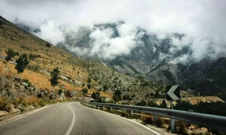 Bochtige bergweg door nevelige bergen in Albanië