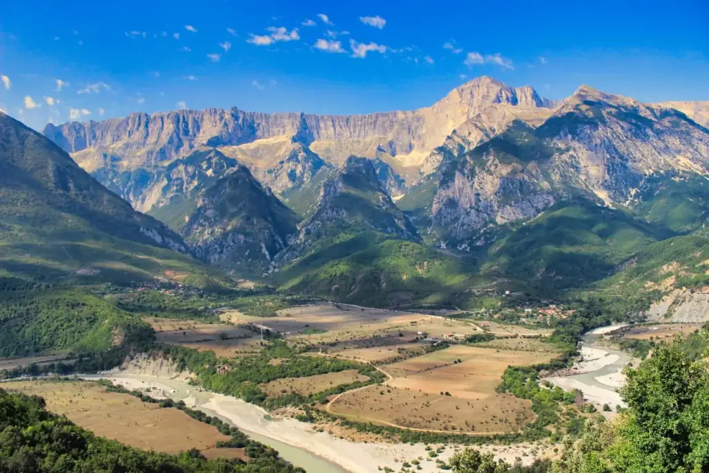 Bergketen en rivierdal in Albanië onder een blauwe lucht
