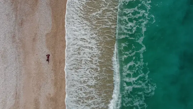Kiezelstrand en turquoise zee aan de Albanese Rivièra vanuit de lucht