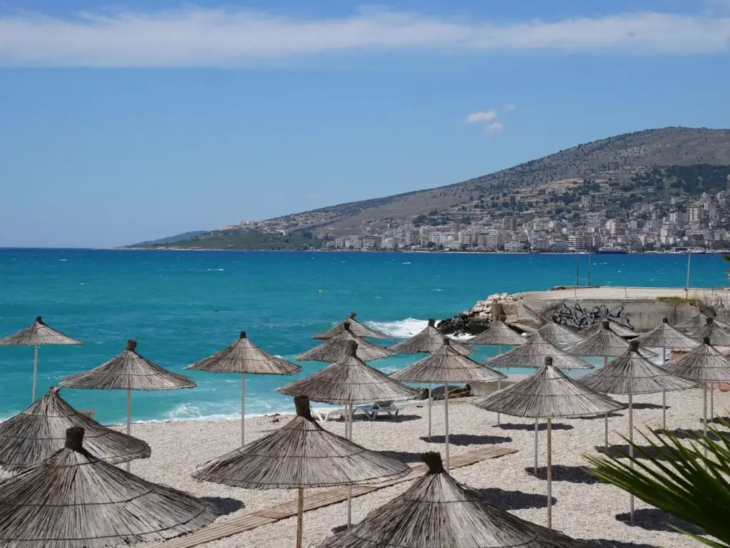 Rieten parasols op het strand bij Sarandë