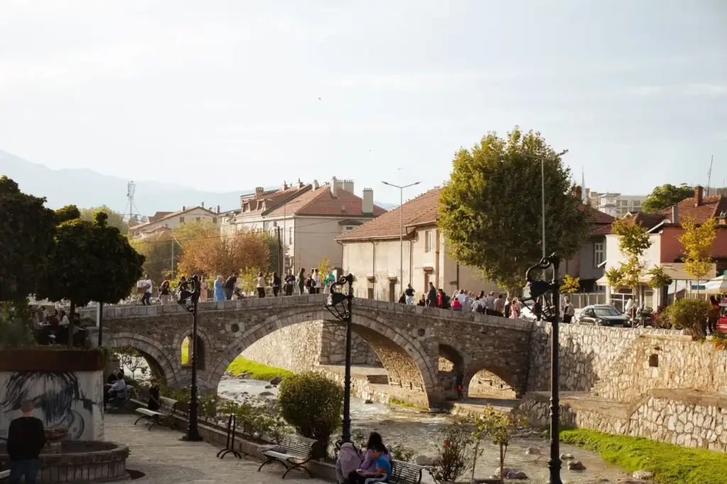 Wandelaars bij de historische stenen brug van Prizren